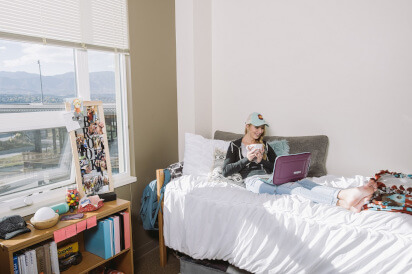 Student studying by a window in her resident room.