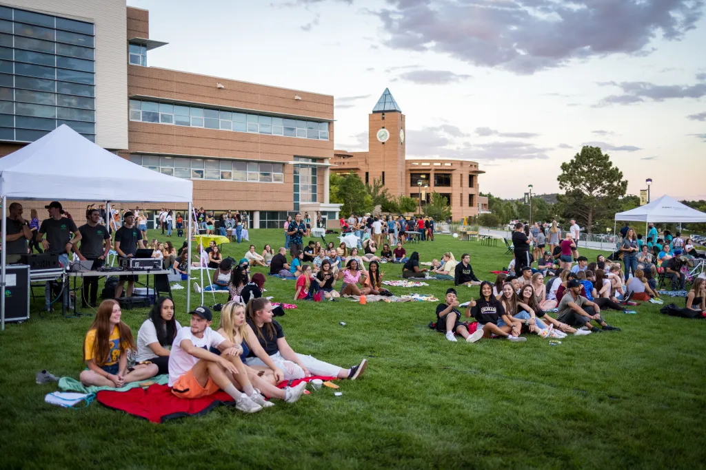 students sitting on the west lawn for student life event